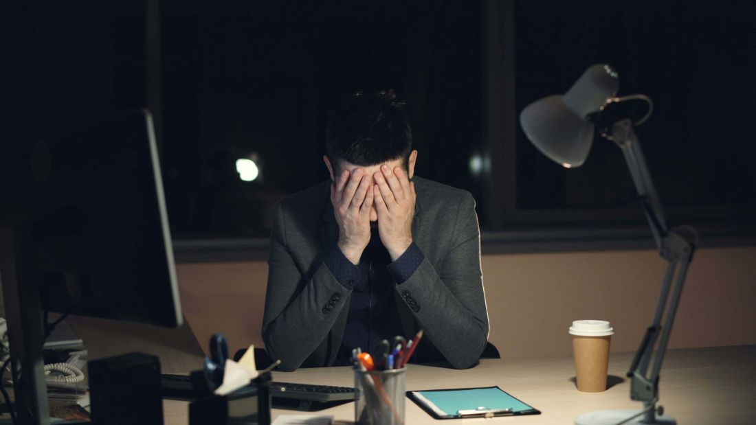 Tired small business owner working late at night on a laptop stressing over messy bookkeeping.